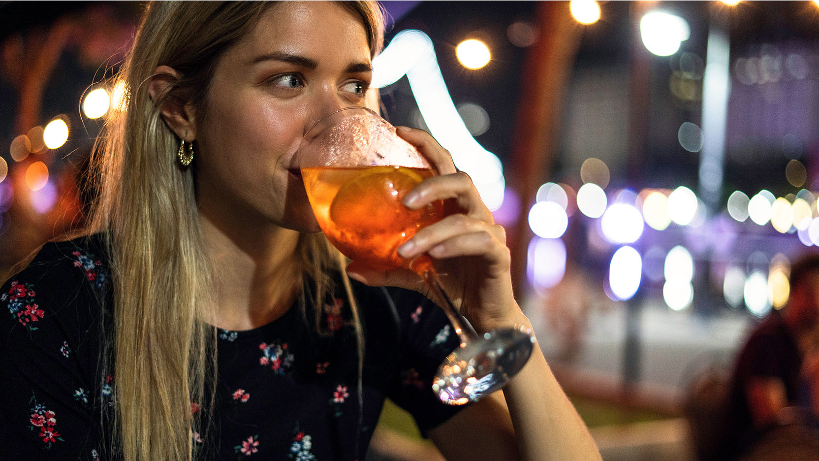 Young woman drinking a cocktail.