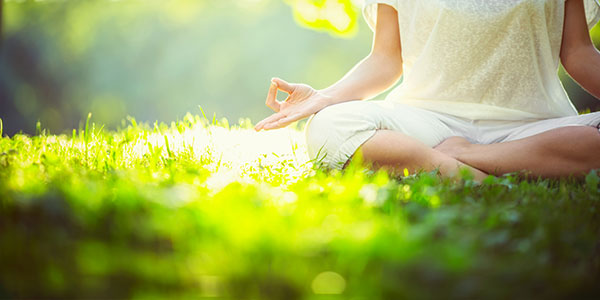 woman meditating in grass