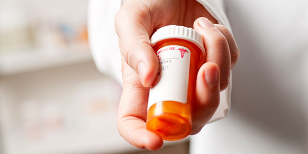 Doctor holding prescription pill bottle