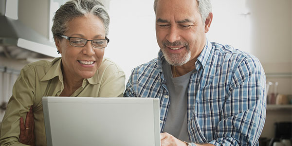 Couple researching on laptop
