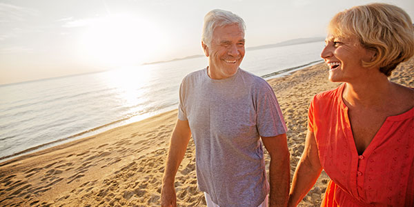 Older couple walking on the beach
