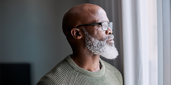 Older black man looking out window