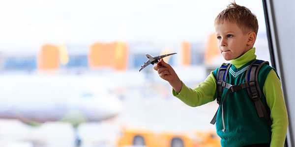 Little boy playing with toy airplane at airport