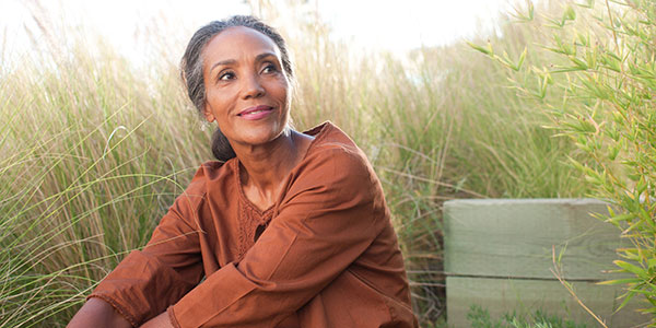 Mature woman sitting in tall grass