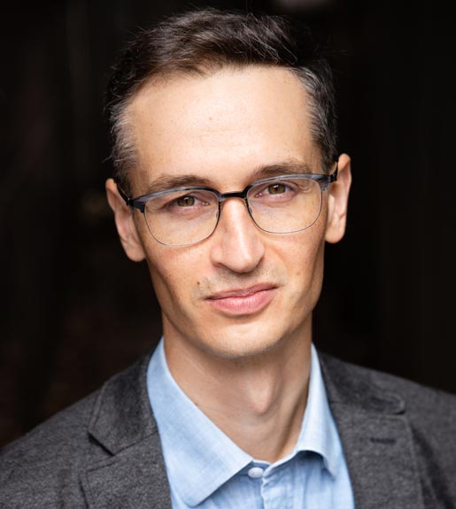 Nicholas Boling, seen from the shoulders up, wearing glasses and looking at the camera
