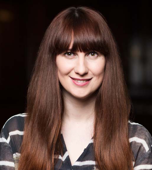 Daisy Smith, seen from the shoulders up, facing forward. She has long brown hair and is smiling.