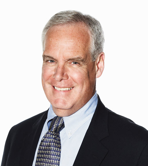 Howard Herring, seen from the chest up in a suit and tie; broadly smiling