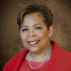 Barbara Polk smiling, wearing a red blazer.