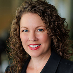 Julia Haase, a woman with curly brown hair wearing a black jacket