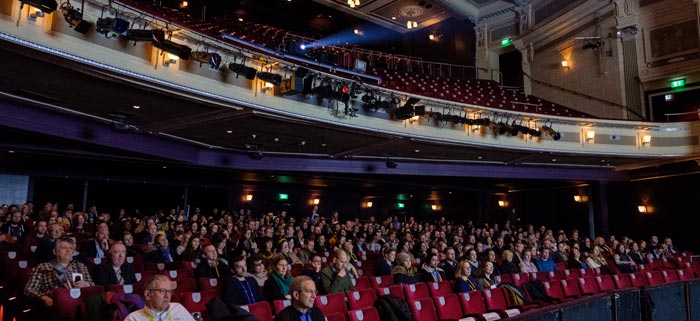 An audience sits in the red velvet seats in the Birmingham Hippodrome.