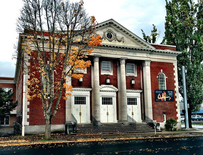 Photo of the Shedd Institute, a brick building with columns and steps leading up to white doors