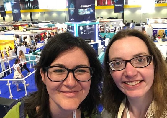 Two women wearing glasses and smiling