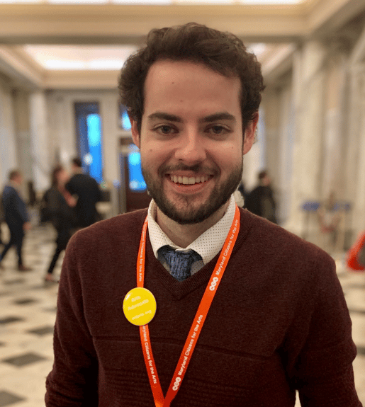 Sean Byrne, seen from the torso up standing in a hallway, facing forward and smiling.