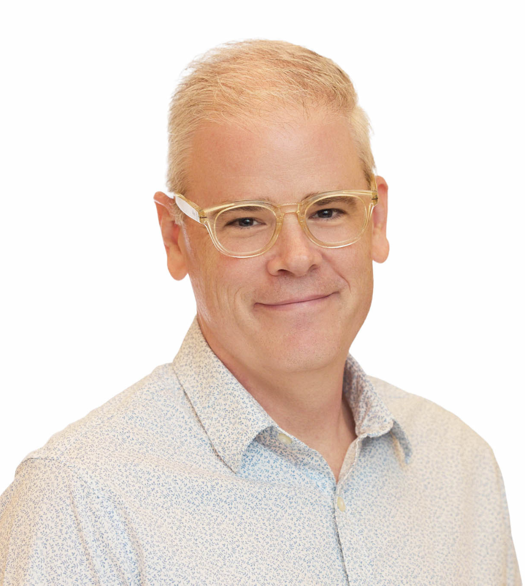 Jeff Oliver headshot. He's wearing clear glasses, a white button up shirt and behind him is a white background.