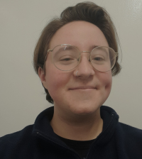 Headshot of Isaac Freeman, a white person with short brown hair, clear framed glasses wearing a black shirt