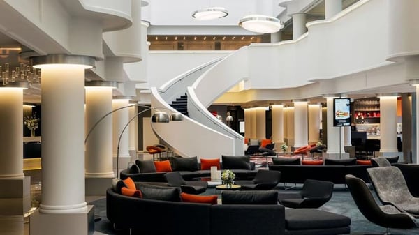 A hotel lobby with a curved staircase and modern furniture