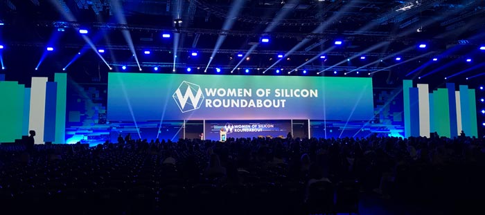 A large screen at a conference reading 'Women of Silicon Roundabout'