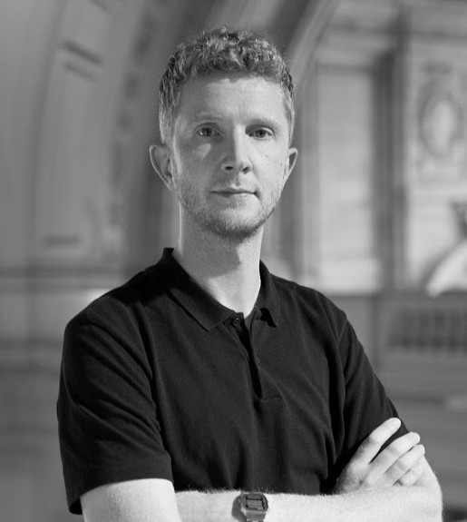 Black and white photo of James Beardsworth-Shaw in front of a blurred background
