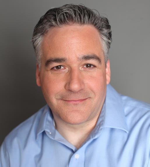 Headshot of Howard Levine, a white man with short gray hair in a blue collared shirt, against a neutral gray background