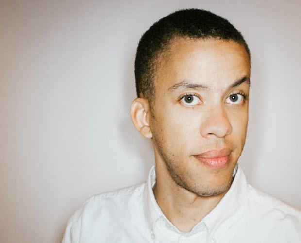 Cedric Blue, an African American man with short black hair, wearing a white collared shirt in front of a neutral wall.