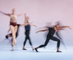 Dancers with motion blur, against a background that fades from pale pink to blue