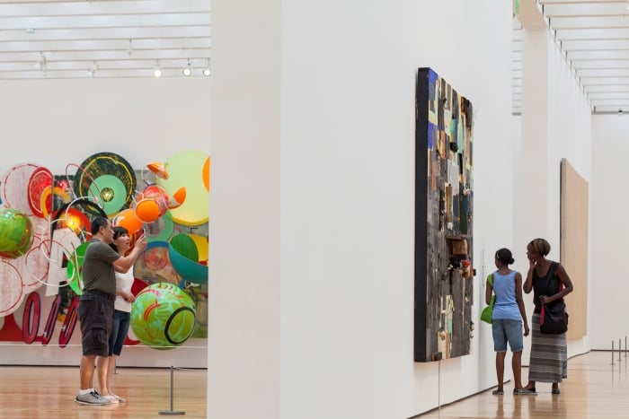 Four guests admire art inside the Wieland Pavilion Skyway galleries at the High Museum of Art.