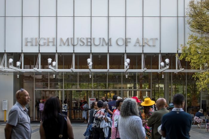 A group of visitors stands outside the High Museum of Art