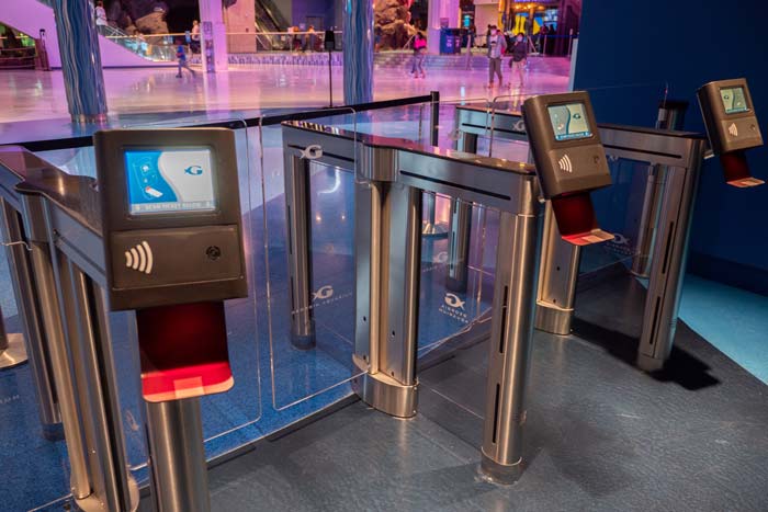 Scanners attached to entry turnstiles that lead to a dramatically lit room.
