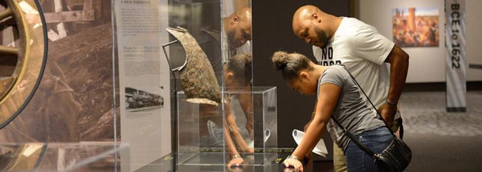 Two people in a museum looking closely at a display case