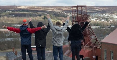 Four children stand atop a hill at Amgueddfa Cymru – Museum Wales.