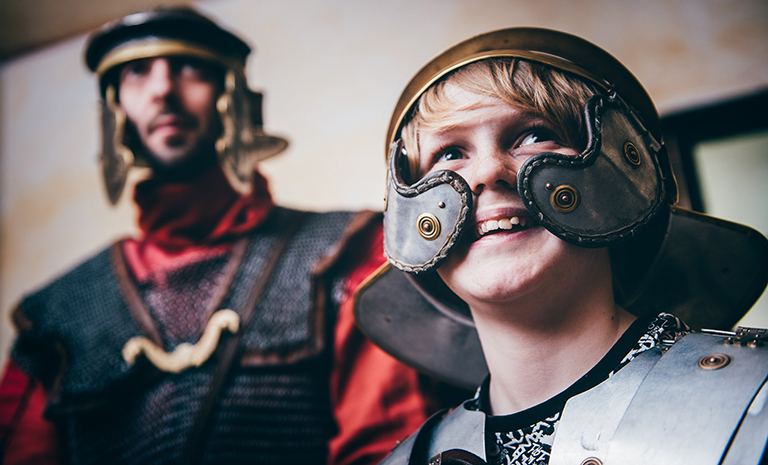 A young visitor tries on replica armour at the National Roman Legion Museum in Wales.