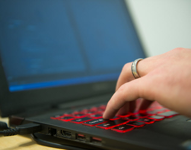 Side view of hands on a laptop keyboard