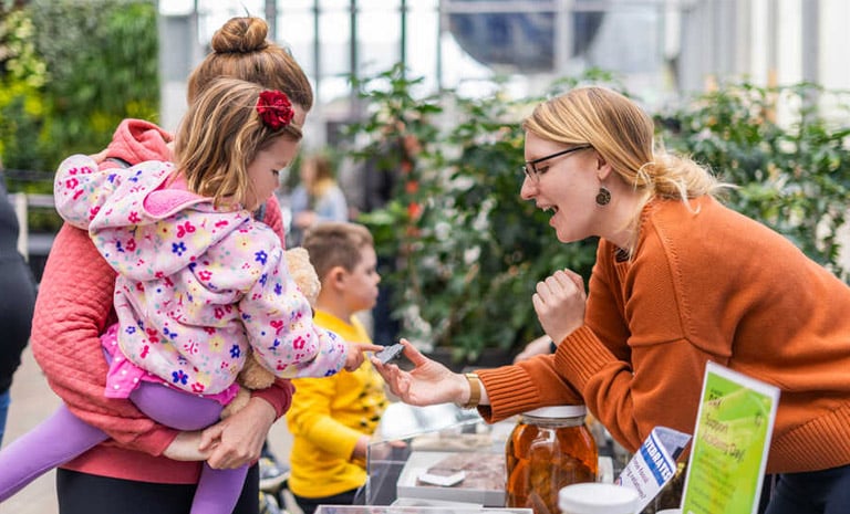 Family visits booth at the California Academy of Science's Academy Day celebration