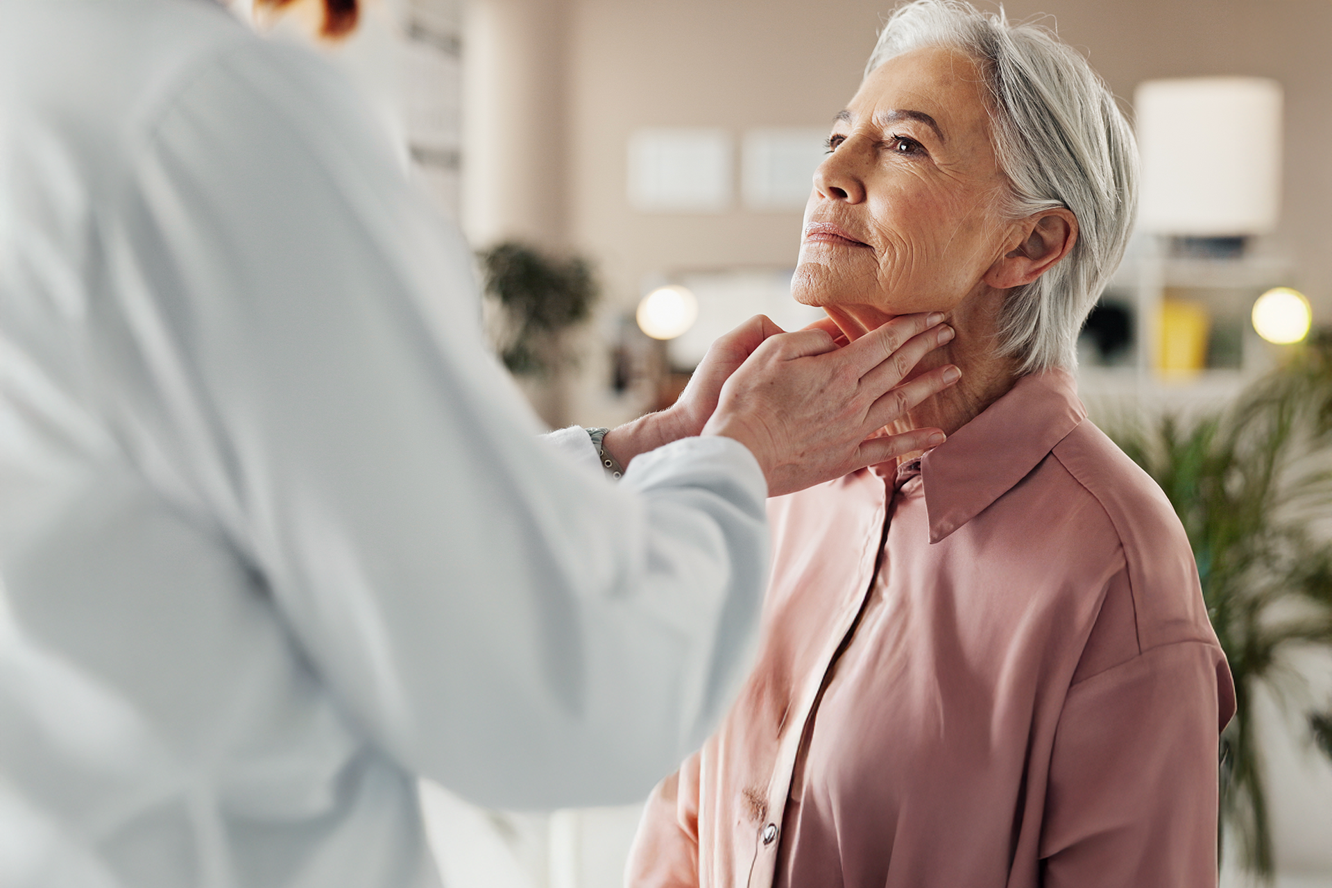 Doctor examining a patient’s neck during a gastrointestinal cancer screening at Texas Oncology.