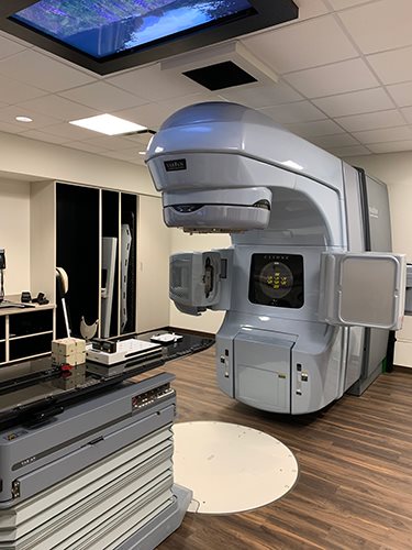 GE CT simulator scanner with patient positioning couch and head immobilization cushion, used for radiation therapy treatment planning