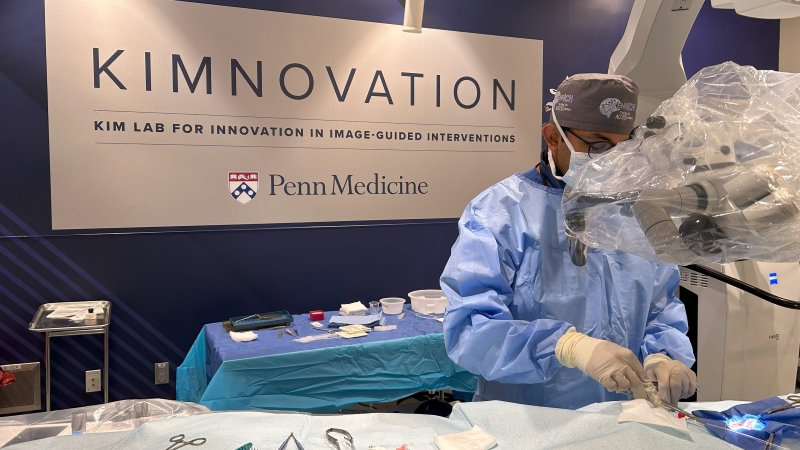 Visish Srinivasan, MD in front conducting research in front of new Kimnovation Lab signage on the wall.