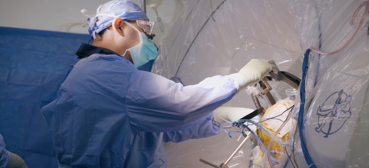 Dr. Iahn Cajigas setting a frame on a patient's head before a DBS surgery.