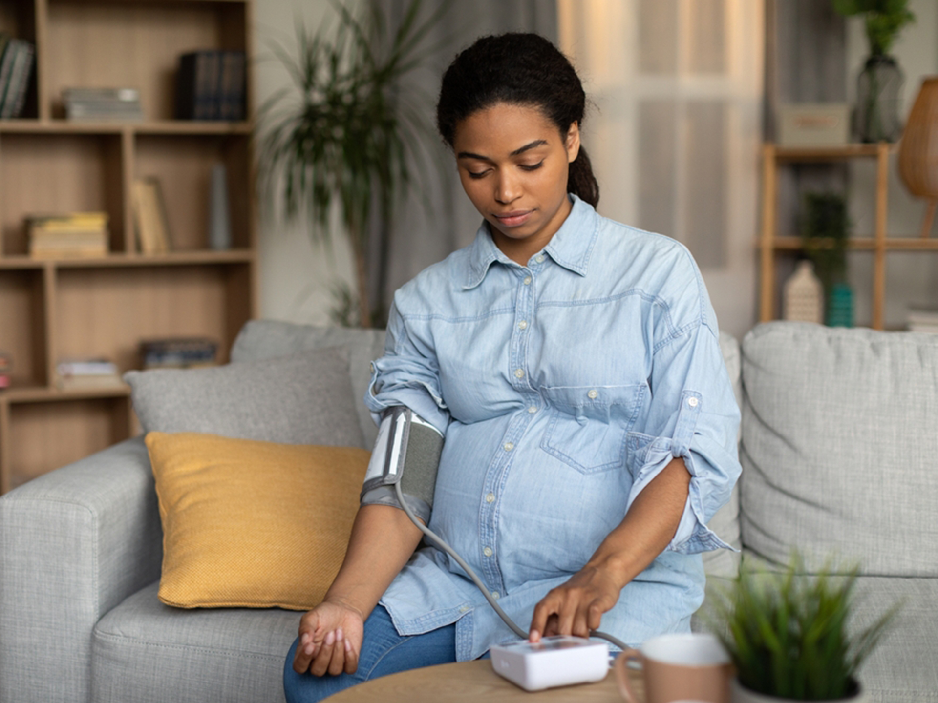 Expecting mother taking blood pressure at home