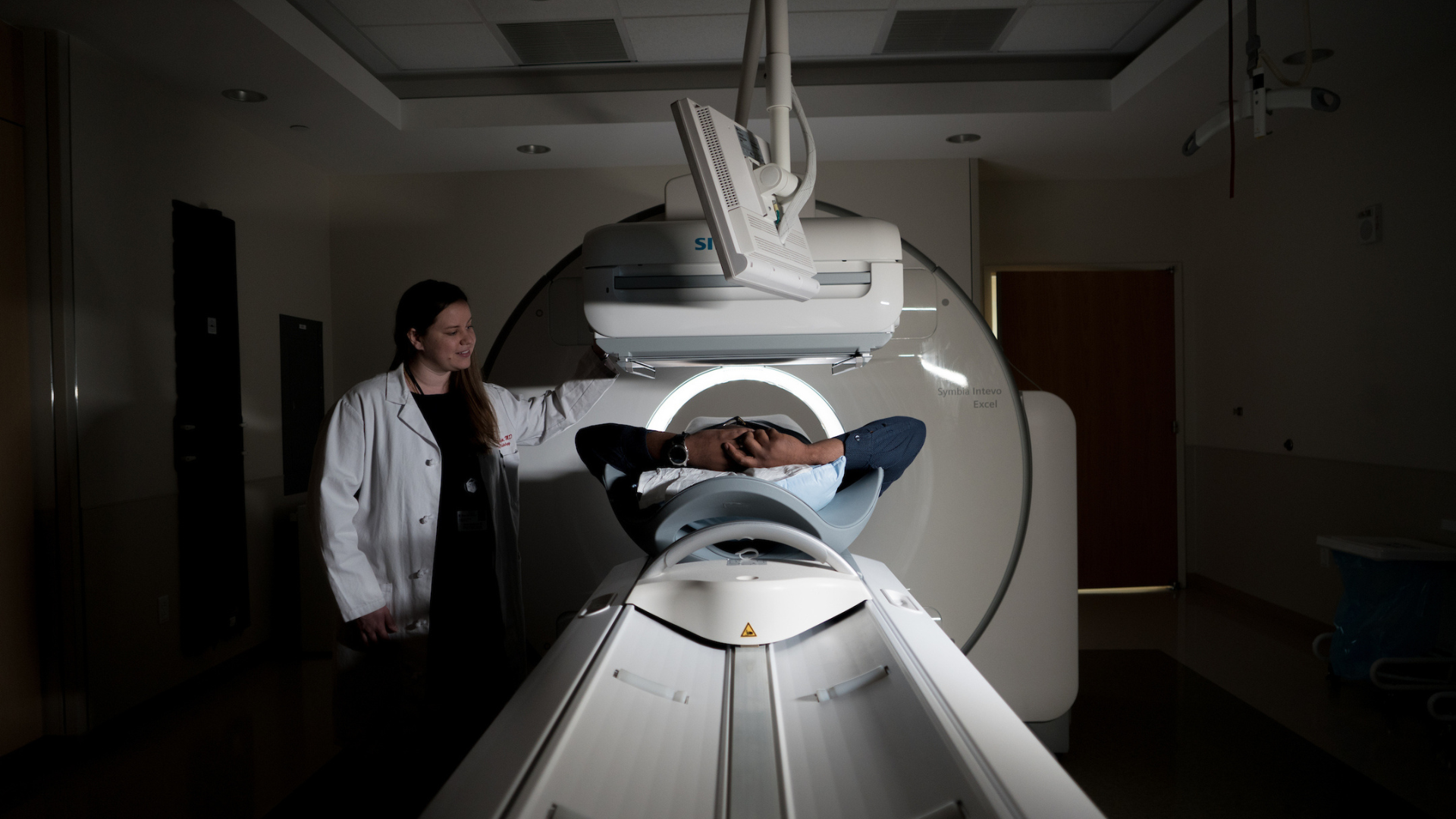A photo of a technician and a patient in an MRI room