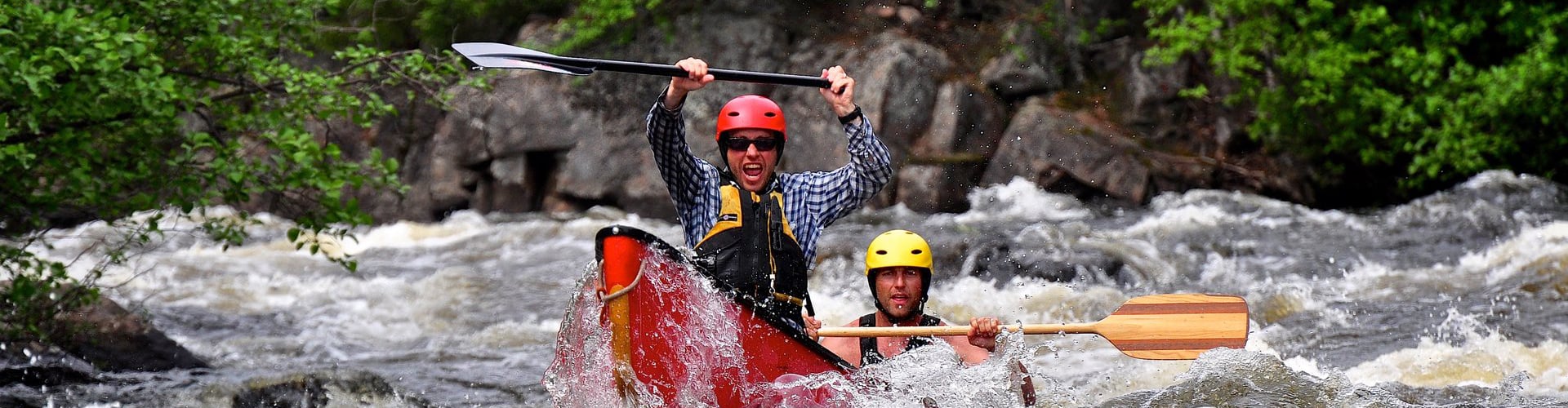 Two men in a kayak on a northern Saskatchewan river, having the time of their lives.