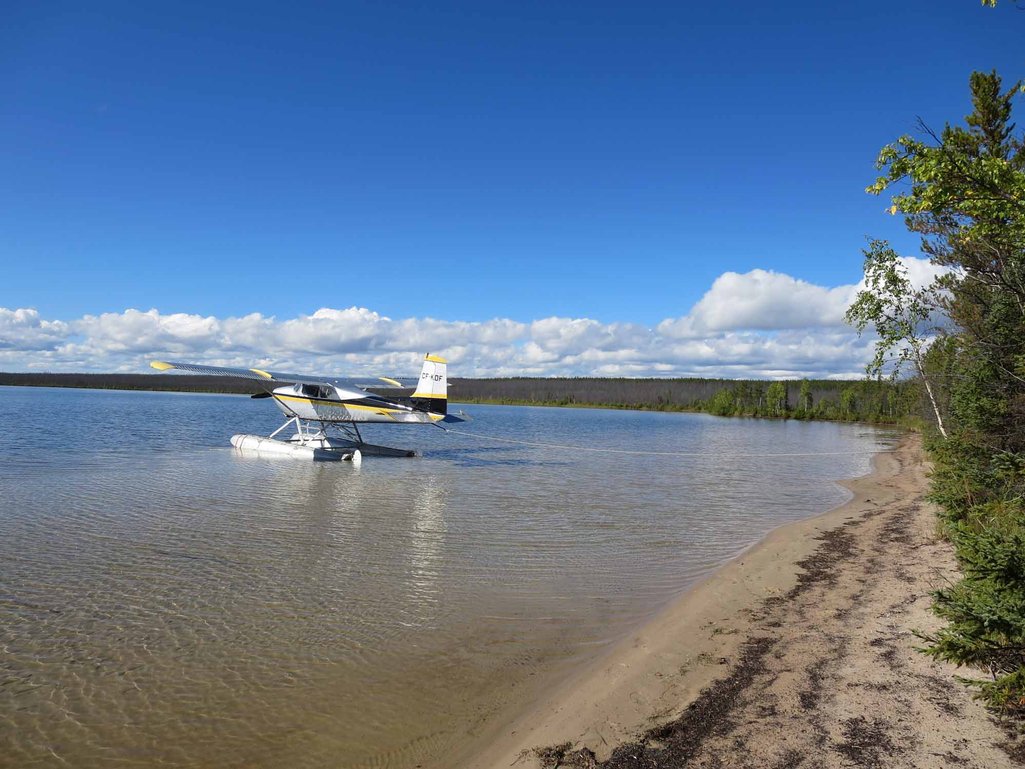 float plane on a lake just off shore in northern saskatchewan