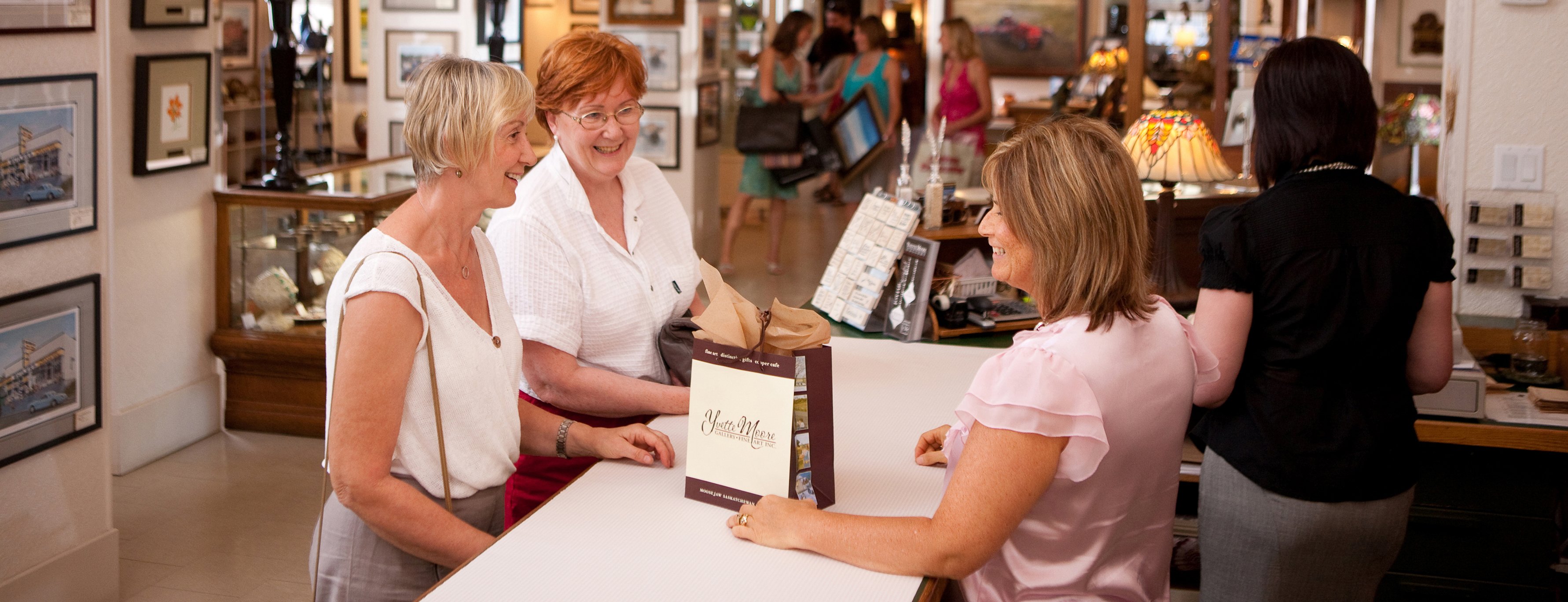 Customer service with two associates helping two customers at checkout counter