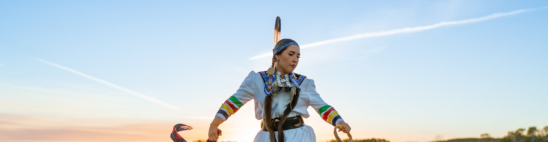 Indigenous woman dancer on a field at evening