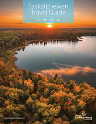 Golden sunset over a lake surrounded by dense forest in Saskatchewan