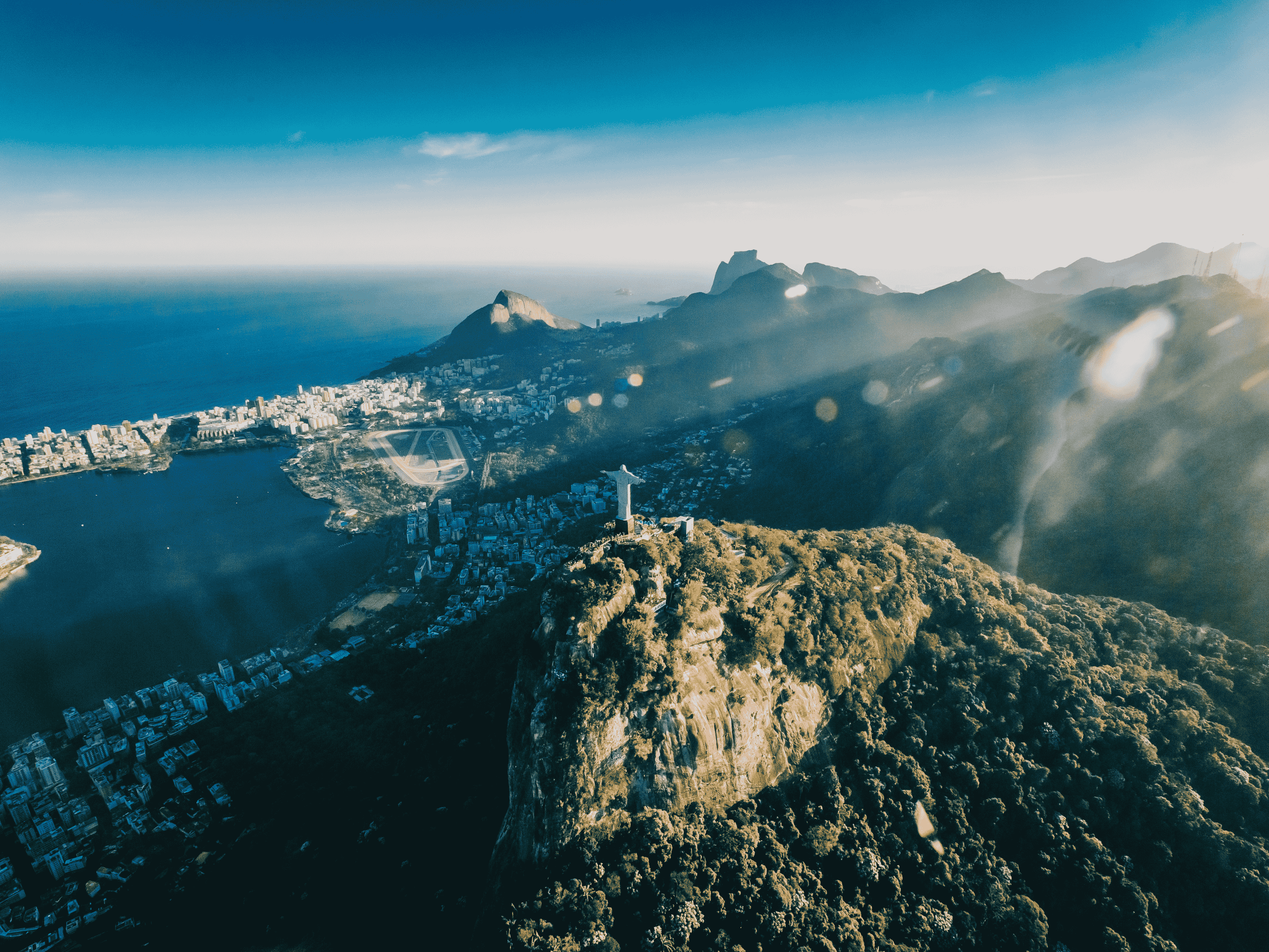 Aerial shot of Rio de Janeiro with Christ the Redeemer in the sunlight
