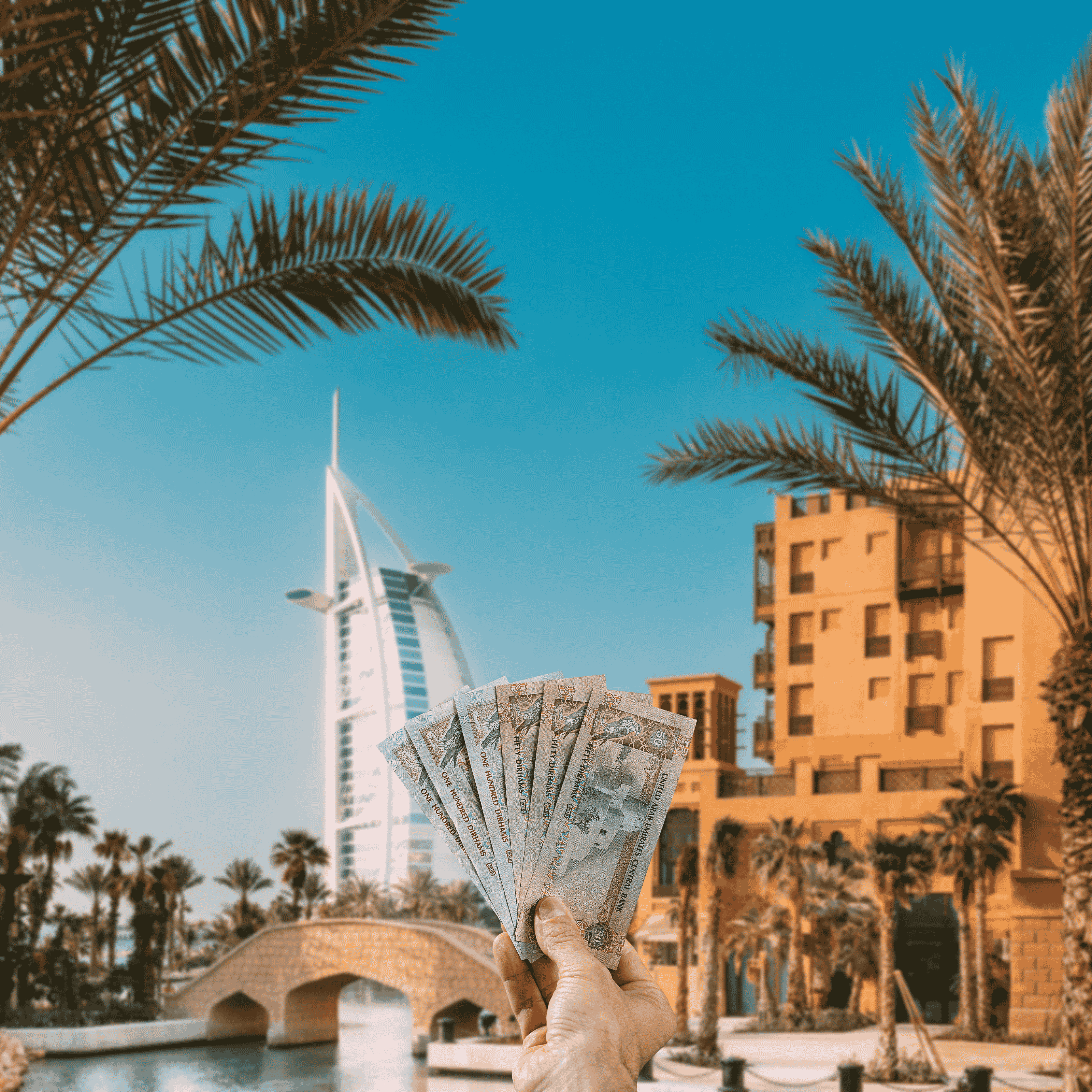 Traveller holding United Arab Emirates Dirhams (AED) in front of Dubai skyline.