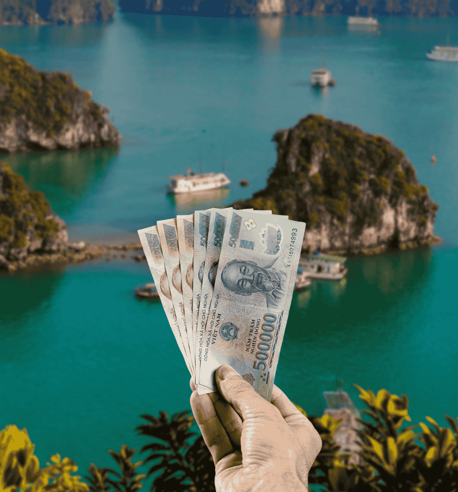 Traveller holding Vietnamese Dong (VND) currency in front of Ha Long Bay, near Hanoi, in Vietnam