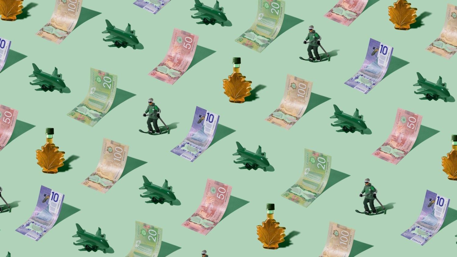 Canadian Dollars (CAD) currency banknotes laid out as a playful pattern with a green plane, bottle of maple syrum and ski figurine for Travel Money Oz.