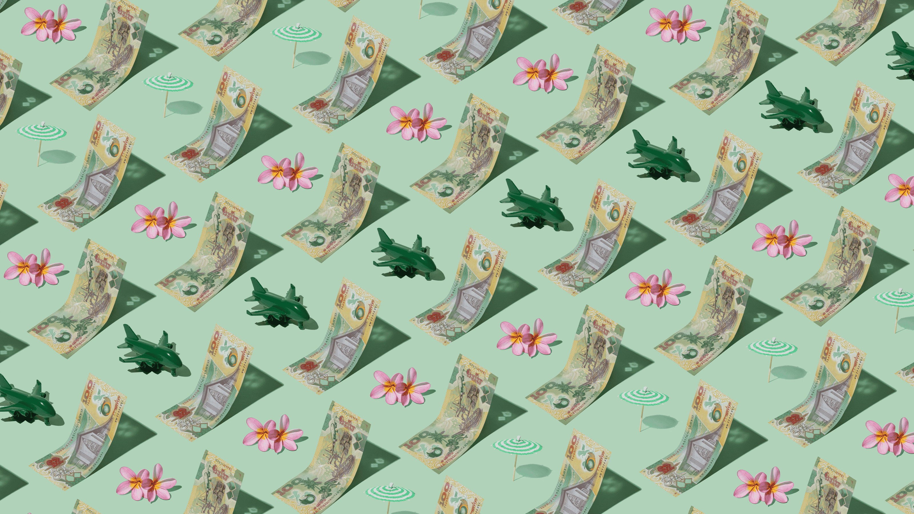 Papua New Guinea Kina (PGK) currency banknotes laid out in a playful pattern with a green plane, green umbrella, and frangipani flower for Travel Money Oz.