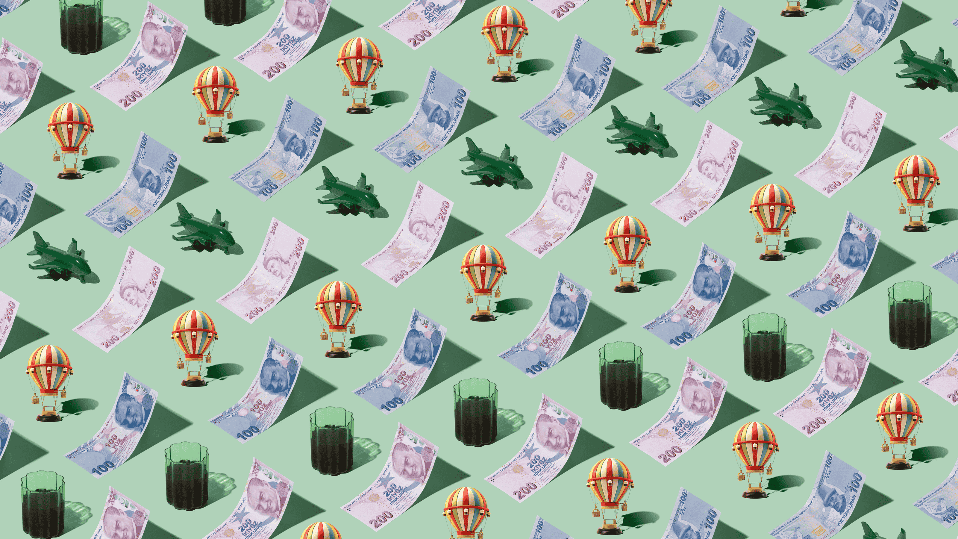 Turkish Lira (TRY) currency banknotes laid out in a playful pattern with a hot air balloon figurine, tea, and green plane for Travel Money Oz.